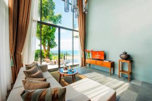 a living room with a couch and a table at Sunsuri Phuket - SHA Plus in Nai Harn Beach