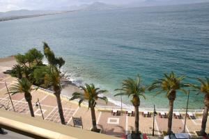 vistas a una playa con palmeras y al océano en Petit Palais Hotel, en Loutraki