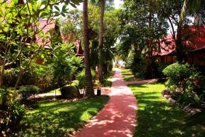 a path through a garden with trees and grass at Longtail Beach Resort in Thong Nai Pan Yai