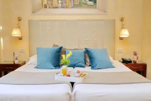 two beds with blue pillows in a hotel room at Hotel Camelia in Rome