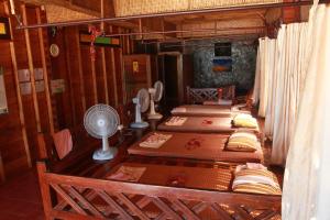 a room with four beds and a fan in a house at Longtail Beach Resort in Thong Nai Pan Yai