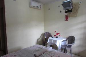 a room with a table and two chairs and a tv at Pousada Pé de Serra Baturité in Baturité