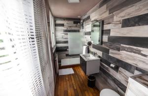 a bathroom with a reclaimed wood accent wall at Cit'Hotel B Hotel in Béthune