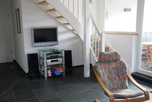 a living room with a tv and a chair at Ferienwohnung "Alte Fischerei" in Ketzin