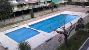 a large blue swimming pool in front of a building at Apartment Llavaneres I in Sant Andreu de Llavaneres