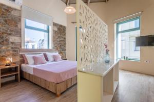 ein Schlafzimmer mit einem Bett und einer Steinwand in der Unterkunft Ancient Agora Apartments in Athen