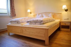 Un dormitorio con una gran cama de madera con almohadas en Haus Partale, en Oberstdorf