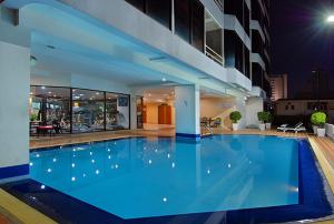 a large blue swimming pool in a building at Tai Pan Hotel - SHA Plus Certified in Bangkok