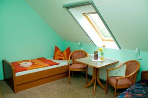 a bedroom with a bed and a table with chairs at Christel's Pension in Brandenburg an der Havel