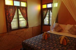 a bedroom with a bed with two towels on it at Longtail Beach Resort in Thong Nai Pan Yai