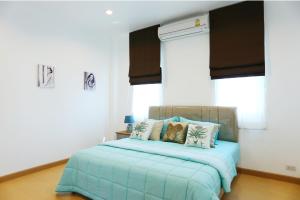 een slaapkamer met een bed met blauwe lakens en kussens bij Thacha Pool Villa A in Hua Hin
