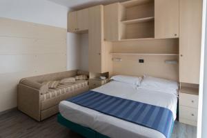 1 dormitorio con 1 cama y 1 sofá en Hotel Christian en Lido di Jesolo