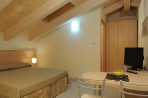 a bedroom with a bed and a table with a television at Residence Belmare in Rimini +84 photos