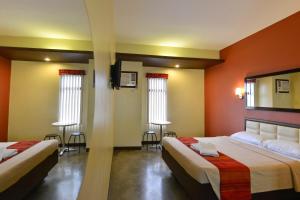 a hotel room with two beds and a mirror at Express Inn Cebu Mabolo in Cebu City