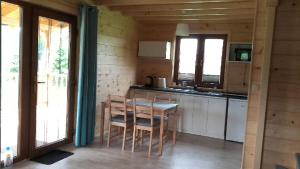 een keuken met een tafel en stoelen in een kamer bij Domek nad jeziorem Ublik in Miłki