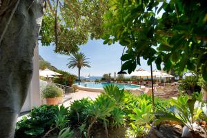 a pool with tables and umbrellas in a resort at Hotel Parco Smeraldo Terme in Ischia