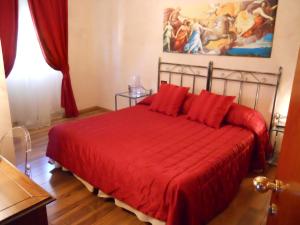 a bedroom with a red bed with a red blanket at Locanda Villa Moderna in Genoa