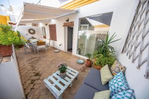 a patio with a blue couch and some plants at Cosy Apartment with Terrace in the Centre of Seville in Seville