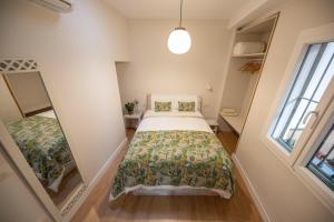 um pequeno quarto com uma cama e uma janela em Cosy Apartment with Terrace in the Centre of Seville em Sevilha