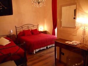 a bedroom with a red bed and a mirror at Locanda Villa Moderna in Genoa