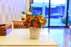 花蓮市的住宿－愛上巴黎民宿，花瓶,花朵红色,坐在桌子上
