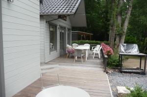 a wooden deck with a table and chairs on a house at 't eekhoorntje in Durbuy