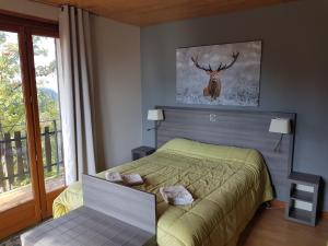 a bedroom with a bed with a deer on the wall at Hôtel Les Chamois in La Bollène-Vésubie