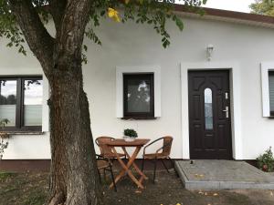 a table and chairs in front of a house with a door at Ferienwohnung Mescherin 2 in Mescherin