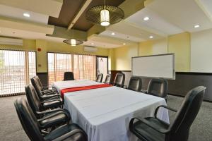 a conference room with a table and chairs and a screen at Express Inn Cebu Mabolo in Cebu City