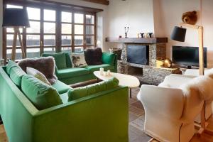 Naut AranにあるNin de Beret 4 by FeelFree Rentalsのリビングルーム(緑の家具、暖炉付)