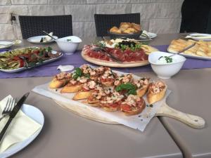 einen Tisch mit Teller mit Lebensmitteln und Schüsseln mit Lebensmitteln in der Unterkunft Guest House Villa Maslina Neum in Neum