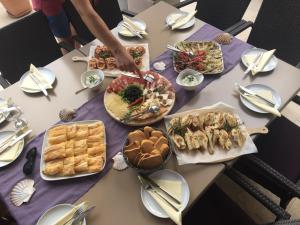 a table with many plates of food on it at Guest House Villa Maslina Neum in Neum