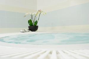 a vase with flowers sitting on top of a bath tub at Penzion s wellness Uherské Hradiště in Uherské Hradiště