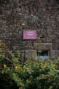 un panneau sur le côté d'un bâtiment en pierre dans l'établissement La Longere d'Helene, à Lauzach