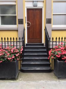 una puerta delantera de una casa con escaleras y flores en The Castle Collection - 3 Union Court en Liverpool