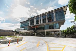 a building with a parking lot in front of it at The Museum Hotel in Nakhon Pathom