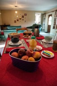 a bowl of fruit sitting on a red table at La Longere d'Helene in Lauzach +12 photos