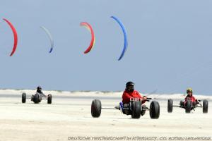 a group of people riding intrack cars on the beach at BORKUMUNTERKUNFT - WOH4 - IM HERZEN DER INSEL in Borkum +1 photo