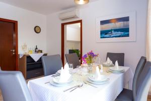 a dining room with a white table and chairs at Villa Divna in Zaboric