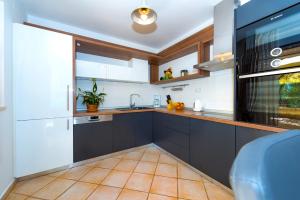a kitchen with black and white cabinets and a sink at Villa Divna in Zaboric