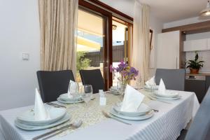a dining table with a white table cloth and silverware at Villa Divna in Zaboric