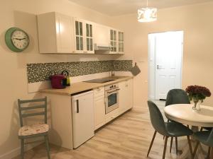 a kitchen with white cabinets and a table with chairs at Ferienwohnung Mescherin 2 in Mescherin