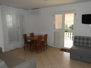 a dining room with a table and chairs and a tv at Zele in Dolac