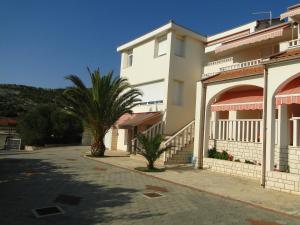 a building with a palm tree next to a street at Zele in Dolac