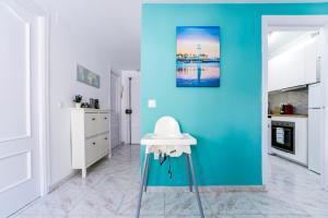 マラガにあるLocal Malaga Apartmentの青い壁のキッチン、テーブルが備わります。