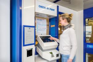 une femme debout à côté d'une machine d'atm dans l'établissement ibis budget Augsburg Gersthofen, à Augsbourg