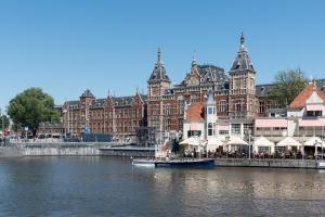 un bateau dans l'eau devant un grand bâtiment dans l'établissement Westerpark Suites, à Amsterdam