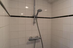 une douche avec pommeau de douche dans une salle de bain dans l'établissement Westerpark Suites, à Amsterdam 27 autres photos