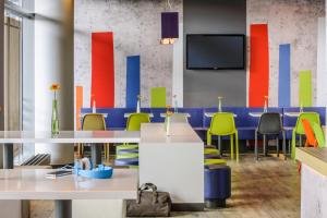 a conference room with tables and chairs and a tv at ibis budget Saarbruecken Ost in Saarbrücken