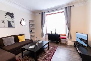 a living room with a couch and a tv at Mycosy Provost Road in Dundee